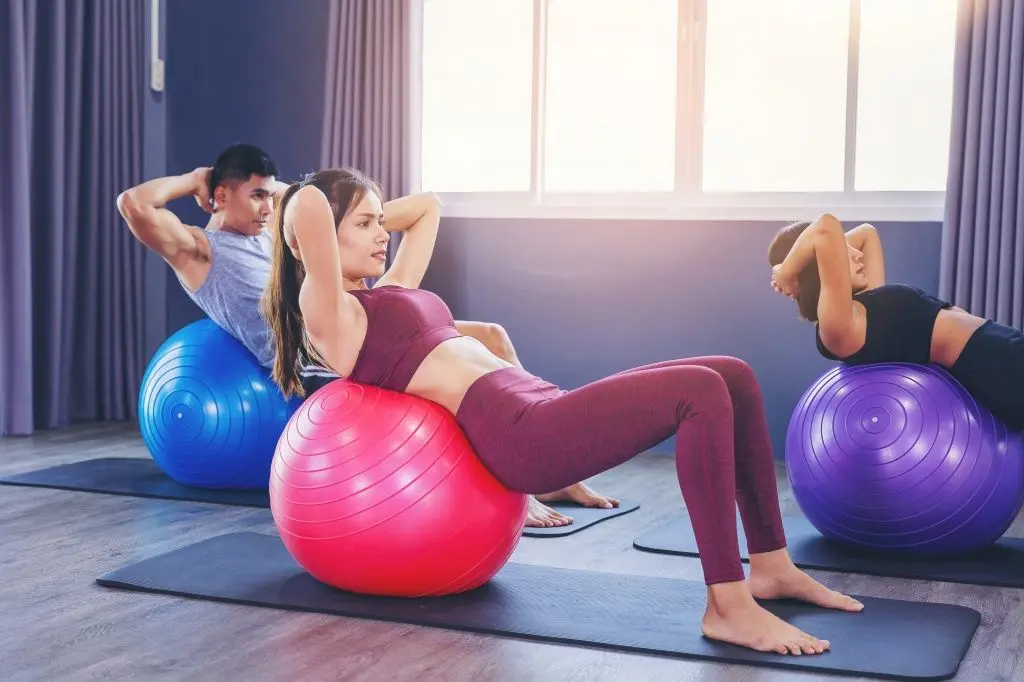 group-fit-people-working-out-pilates-class-with-fitness-ball.jpg